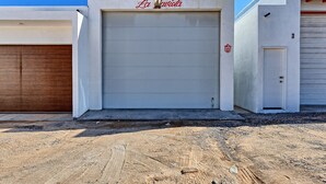 Un bâtiment avec une porte de garage fermée, une enseigne indiquant « La Carioca » et un petit panneau rouge signalant la présence d’un restaurant.