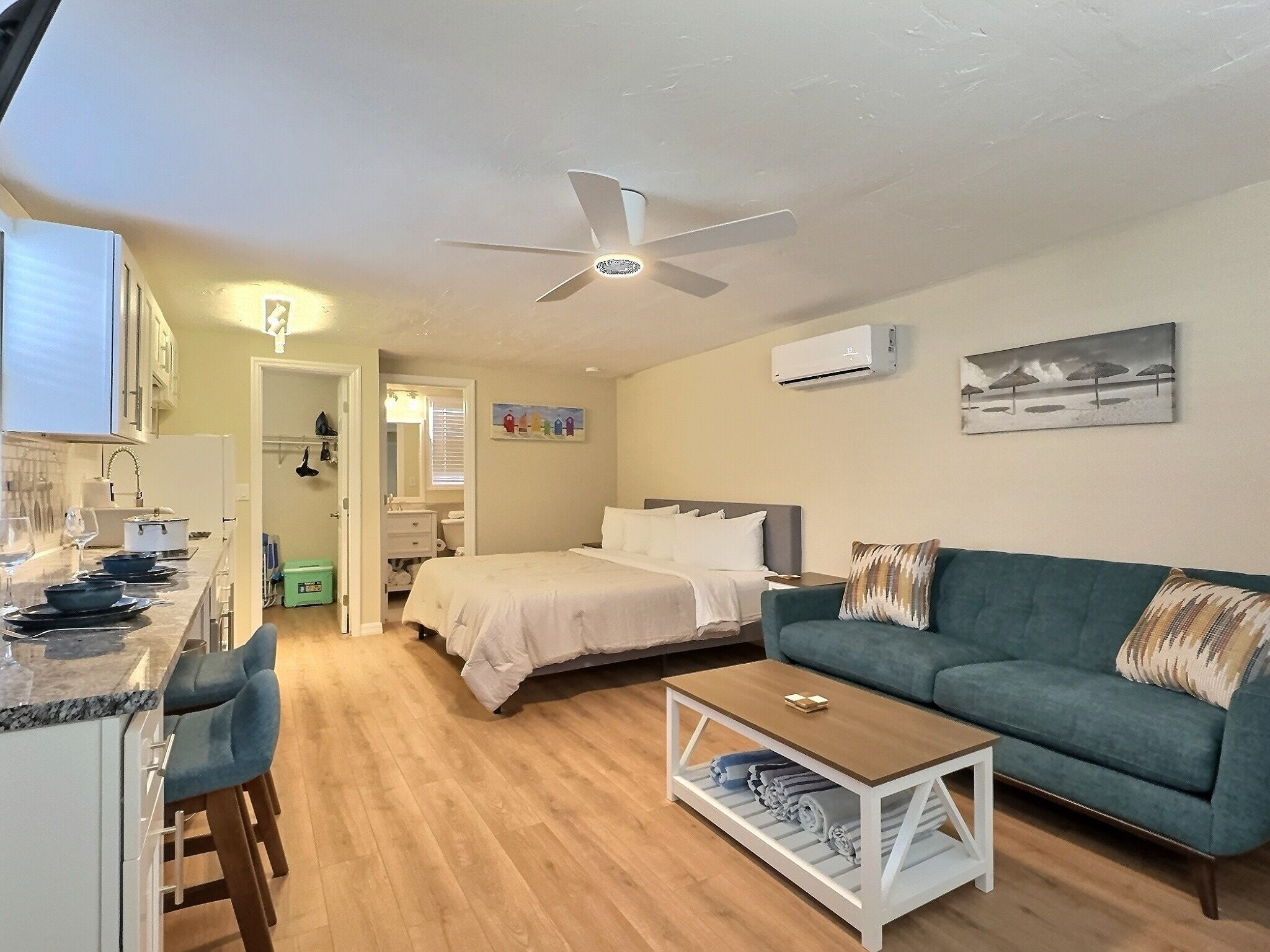 A well-lit, modern living room with a ceiling fan, a bed, a sofa, and a coffee table.