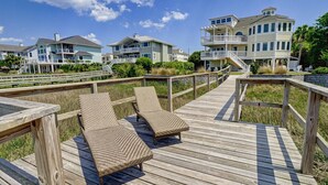 A wooden deck with two lounge chairs and a wooden railing. - RARE Oceanside 5BR Waterfront Home w/ pvt Dock! (Wrightsville Beach)
