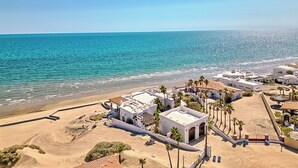 Une station balnéaire avec des bâtiments blancs, des palmiers et une plage.