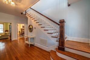 A staircase with wooden steps and white balusters, leading to an upper floor. - Classically Current Home on Park, Near Beach (Cape Charles)