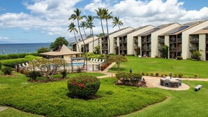 A hotel with multiple-story buildings, a swimming pool, and a view of the ocean.