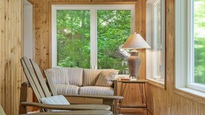 Una habitación con paneles de madera, un sofá, sillas, una mesa y una lámpara.