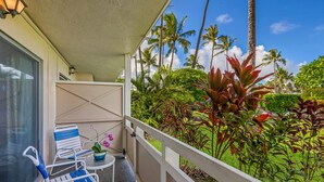 A balcony with a view of tropical plants and palm trees.