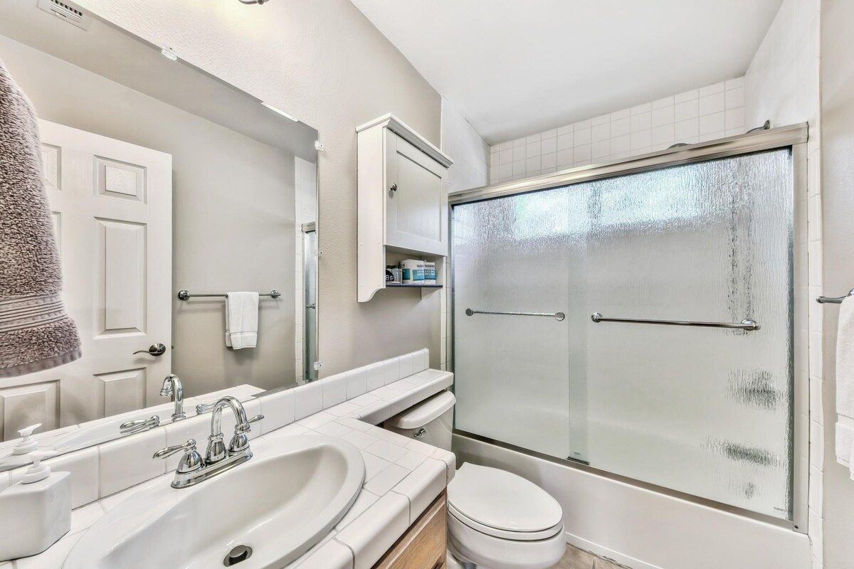 A bathroom with a bathtub, a toilet, a sink, and a glass-enclosed shower.
