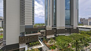 A high-rise building with multiple floors, large windows, and a rooftop garden. - Ocean view studio with washer/dryer, FREE parking & Wi-Fi! (Honolulu)
