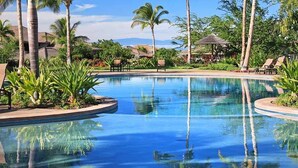 A pool with lounge chairs and palm trees. - Local Luxury Living! (Kamuela)