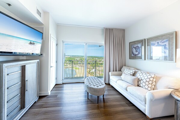 A modern living room with a white sofa, a cushioned bench, and a flat-screen TV on a wooden cabinet.