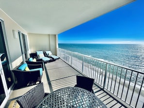 A balcony with wicker furniture and a view of the ocean.