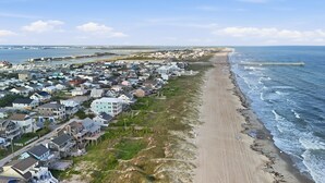 Une zone résidentielle côtière comprenant des maisons, une plage et une jetée.