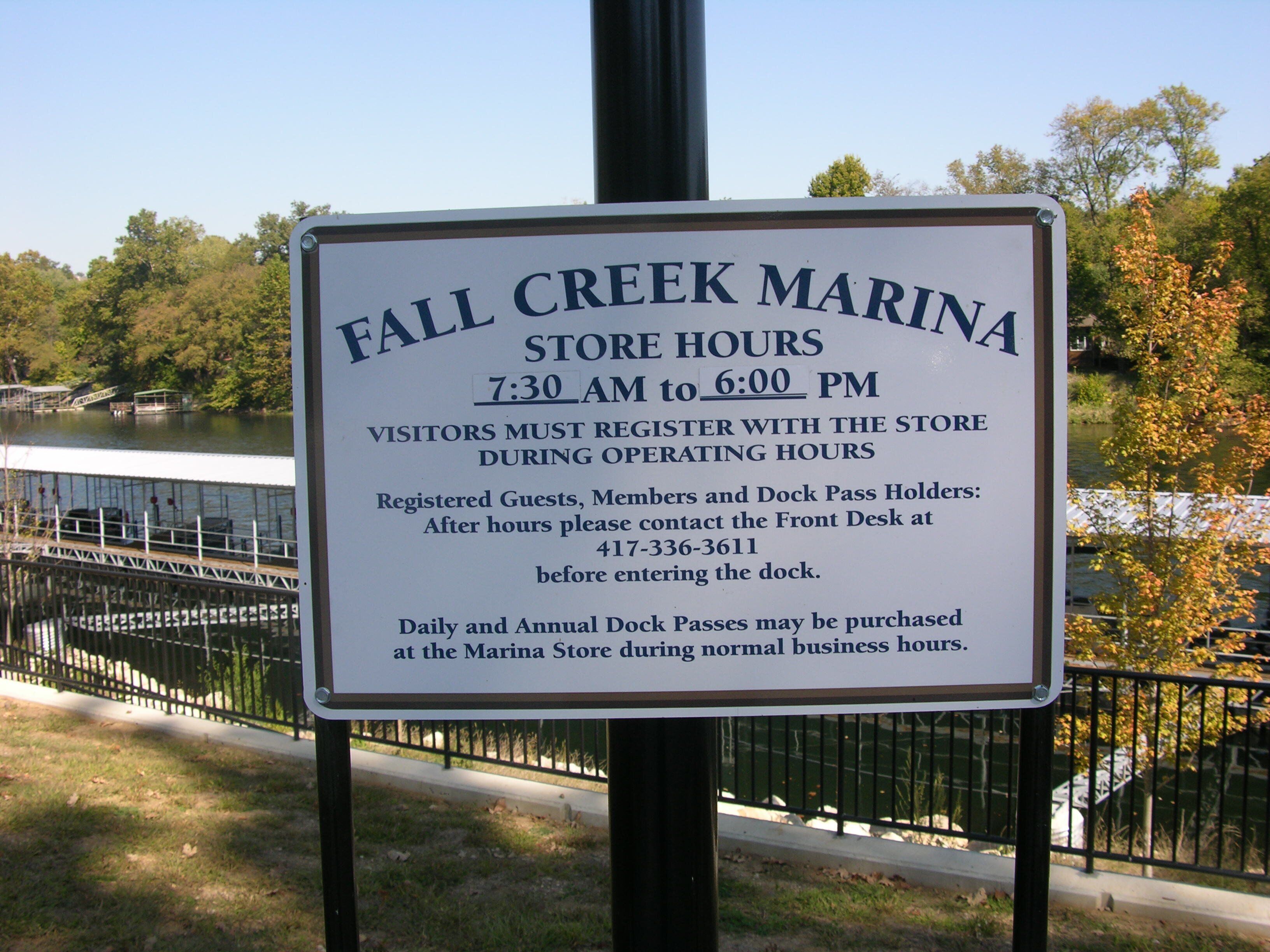 Señal para el puerto deportivo Fall Creek, con el horario de atención indicado de 7:30 a las 18:00.