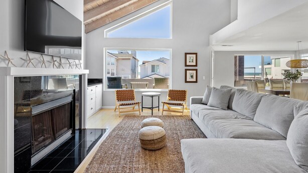Ein modernes Wohnzimmer mit Kamin, Sofa und Essbereich.
