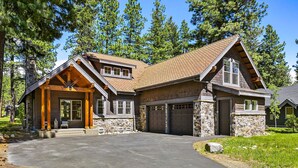 A two-story log cabin with a stone foundation, a large garage, and a covered front porch. - Must See Suncadia Retreat! 3 Masters * Hot Tub * Game Room * On the Course! (Cle Elum)