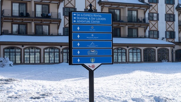 A sign with directions to various hotel amenities including ski and express rental, seasonal and day lockers, and an adventure center. - Ski-In/Ski-Out Creekside Condo with Private Hot Tub at Boyne Mountain (Boyne City)