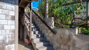 Un escalier avec des marches en pierre et des rampes en métal, menant à un niveau supérieur.