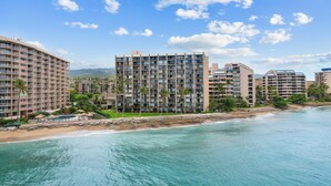 Ein Strandhotel mit mehreren Gebäuden, einem Sandstrand und blauem Himmel.