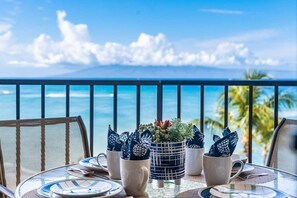 A table set for dining with a view of the ocean and palm trees. - BeachFront 1BR w Sunset Ocean Views Pool -Valley Isle 902 (Lahaina)