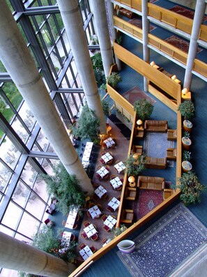 A spacious atrium with multiple levels, featuring a central seating area with sofas and tables, surrounded by potted plants and a patterned carpet. - Prime Ski Week at Snowbird's Cliff Club Sleeps 6 in 1bedroom (Sandy)
