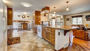 A spacious kitchen with wooden cabinets, a central island, and pendant lighting.