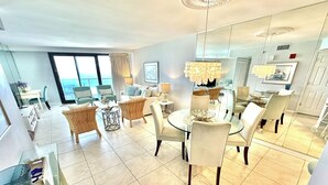 A modern living room with a dining area, large windows, and a view of the ocean. - Fabulous gulf/beach views from the 14th floor! 4336BS2 (Miramar Beach)