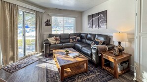 A living room with a leather sofa, wooden coffee table, and a rug.
