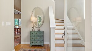 A staircase with a glass door leading to a dining area.