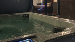 A hot tub with a smartphone on the edge. - 15 min from the Mont Tremblant Ski Hills, Perfect for Families and Friends ! (La Conception)