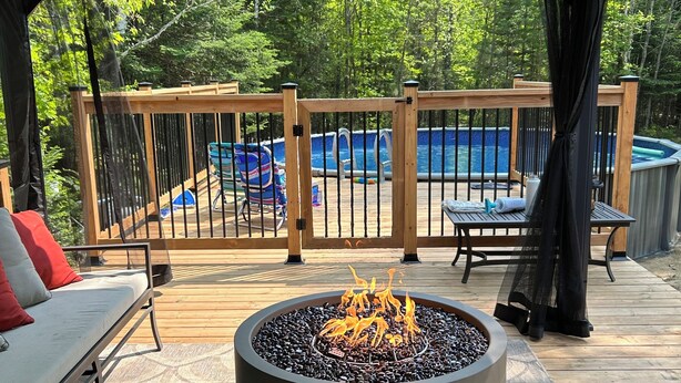 A covered outdoor deck with a fire pit, a pool, and a lounge area. - 15 min from the Mont Tremblant Ski Hills, Perfect for Families and Friends ! (La Conception)