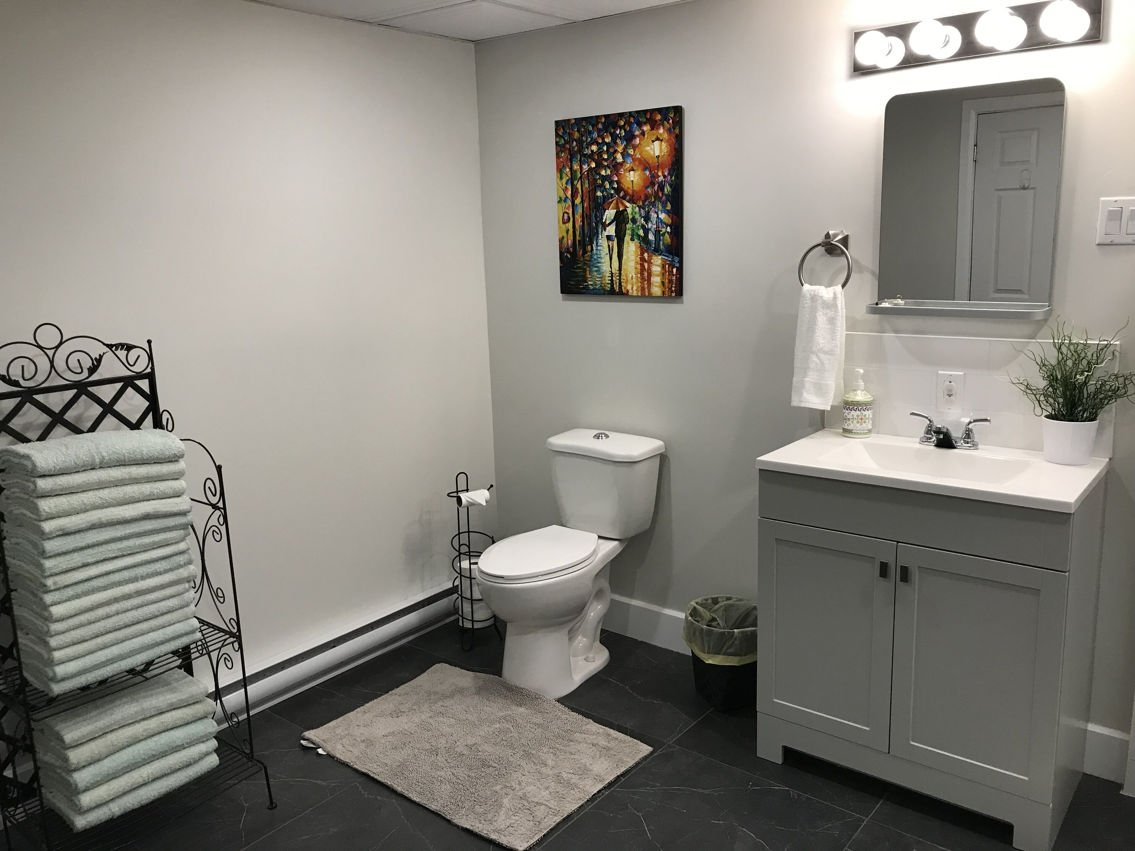 Een moderne badkamer met toilet, wastafel en handdoekhouder.