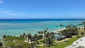 A resort with a pool, palm trees, and a view of the ocean.