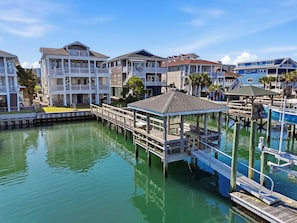 A waterfront property with a dock, a gazebo, and multiple buildings with balconies.