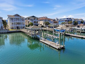 A marina with docked boats, a pier, and waterfront buildings.