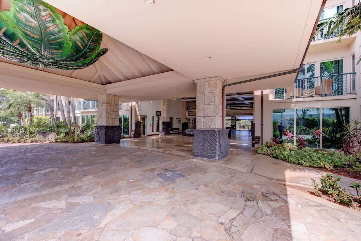 A spacious lobby with stone flooring, large columns, and a ceiling mural.
