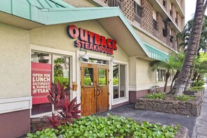The exterior of Outback Steakhouse with a sign indicating it's open for lunch on Saturday and Sunday at 11 AM. - Waikiki Marina-Front Condo! Ocean & Fireworks View, Central AC, Full Kitchen! (Honolulu)