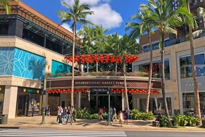 An International Market Place with palm trees, a Rolex store, and a Tekla building.