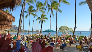 A beachside restaurant with outdoor seating, palm trees, and a view of the ocean. - Ocean View Lanai and an Easy 5–10-min walk to beach! FREE Wi-Fi, Full Kitchen (Honolulu)