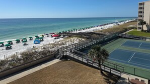 A beach view with a tennis court and a building with balconies. - 422 - Beautifully Renovated with Gorgeous Views  and FREE bch svc (Destin)