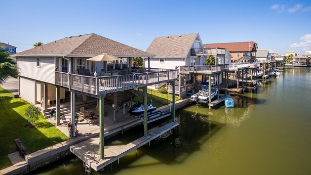 A waterfront property with a dock, a covered patio, and a boat dock. - Beautifully remodeled canal home, short walk from beach! Pet friendly, WiFi (Galveston)