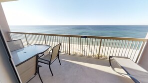 Enjoy ocean views from this balcony with a table and two chairs for dining or relaxation.
