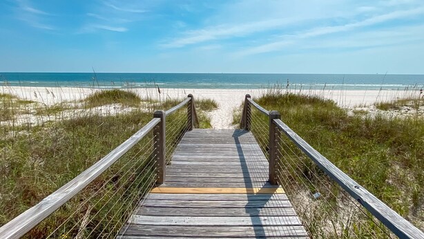 A wooden boardwalk leading to a beach with a clear sky. - Kiva Grand by GSVR | Spectacular Beachfront Family Retreat w/ Pool & Hot Tub + FREE Activities/Golf (Gulf Shores)