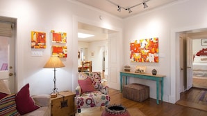 A living room with a sofa, a table, a lamp, and artwork on the walls. - Tres Puertas (Santa Fe)
