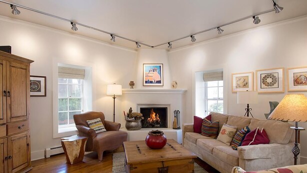 A living room with a fireplace, wooden furniture, and artwork on the walls. - Tres Puertas (Santa Fe)