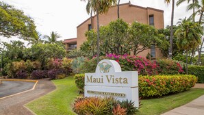 A sign for 'Maui Vista' at 2191 South Kihei Road, surrounded by lush greenery and palm trees.