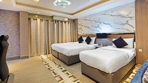A hotel room with two beds, a ceiling fan, a marble wall, and a patterned rug. - Trans World Hotel L.L.C (Dubai)