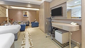 A hotel room with a bed, a desk with a chair, a TV, and a bathroom area. - Trans World Hotel L.L.C (Dubai)