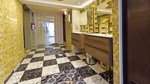 A modern bathroom with a checkered floor, wooden vanity, and a large mirror. - Trans World Hotel L.L.C (Dubai)