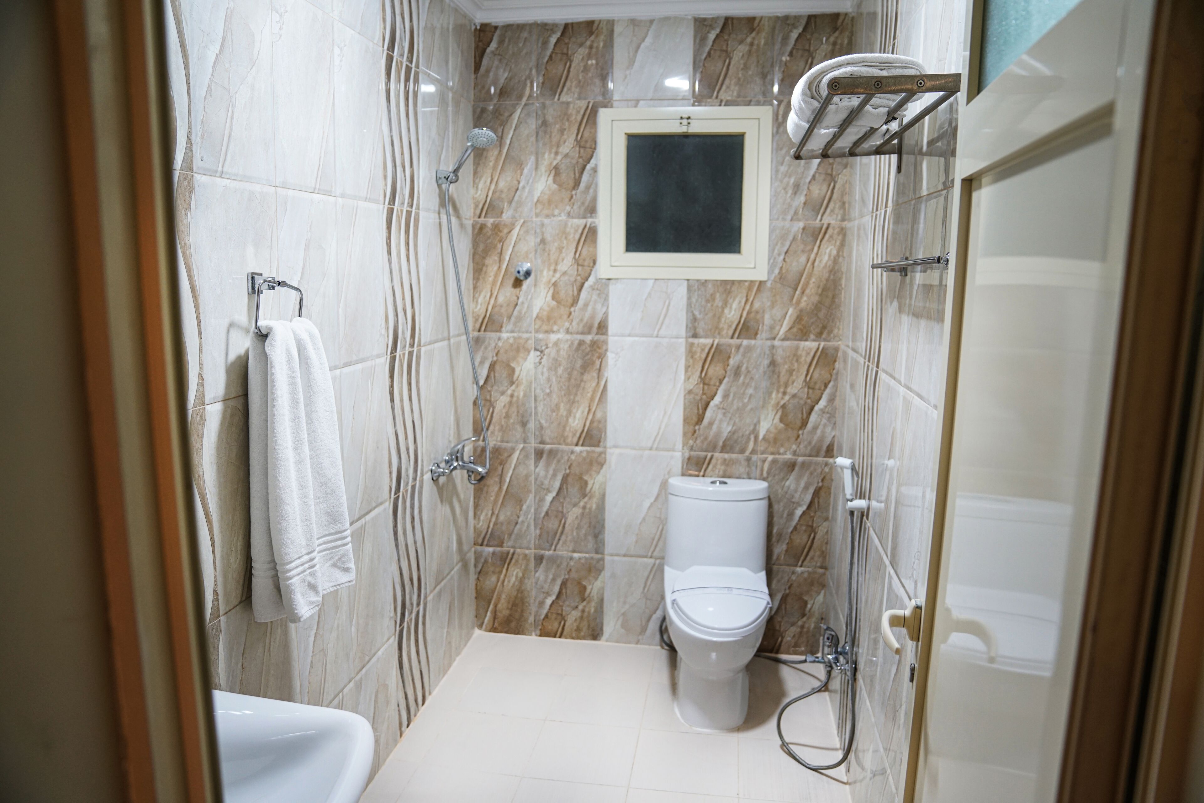 A small, modern bathroom with a toilet, a shower, and a sink.