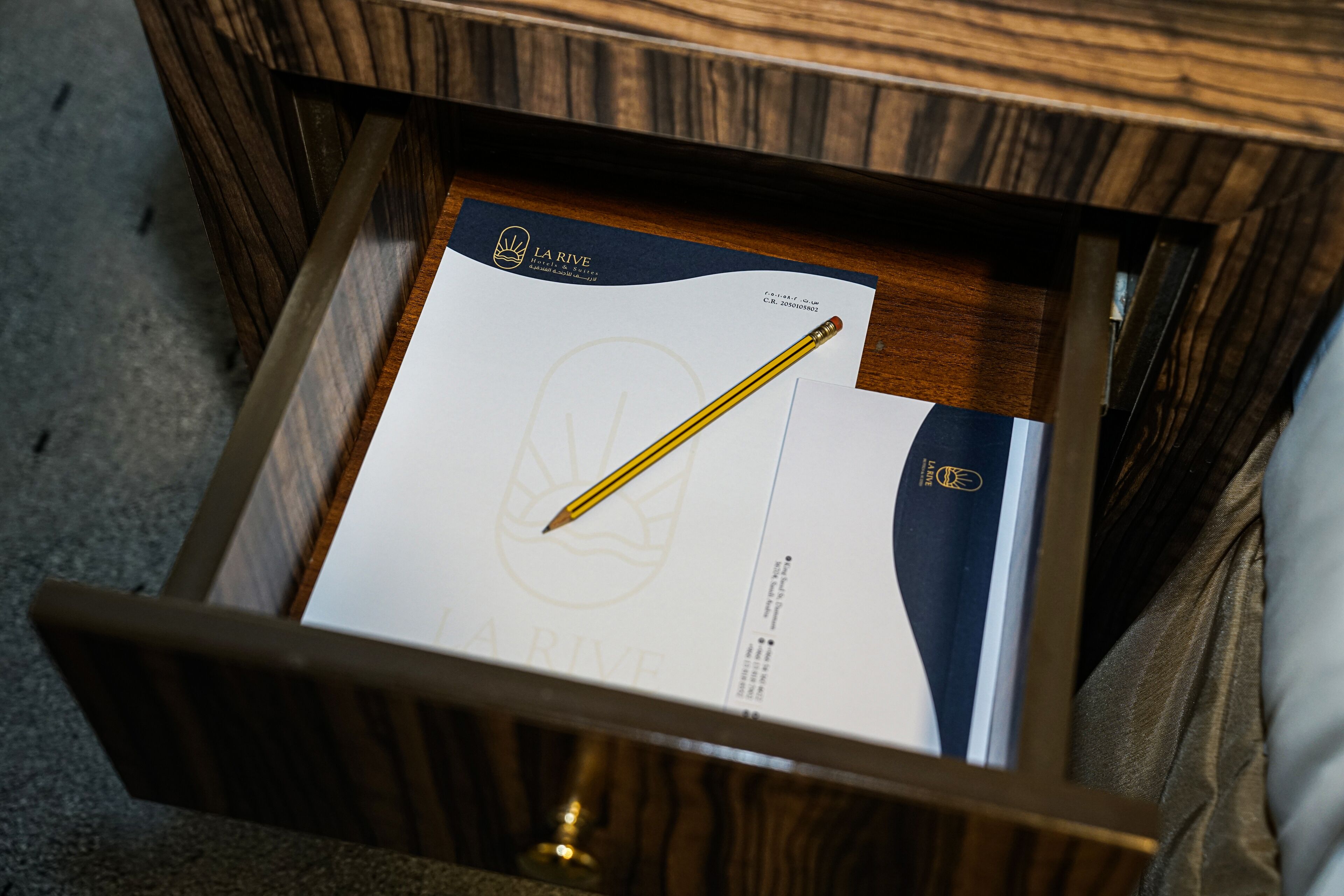 A drawer with a document and a pencil.