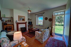 Casa de campo tradicional, 2 habitaciones, vistas al jardín | Zona de estar | Una televisión de pantalla plana, un reproductor de DVD, libros