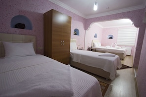 Un dormitorio con dos camas, un armario y un baño con espejo.